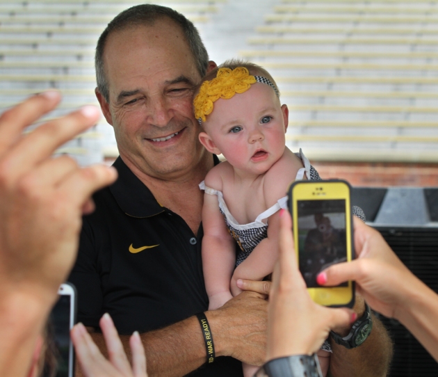 MU football coach Gary Pinkel holds 8-month-old Bristol Kennedy at the annual Fan Day event on Sunday, Aug. 10, 2014, at Memorial Stadium. Bristol is the daughter of Robert and Secley Kennedy of Columbia. Photo by Karen Mitchell